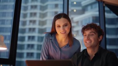 İş arkadaşları akşam ofisindeki sanal toplantılarda konuşuyorlar. İş kadını işadamı karanlık işyerindeki video görüşmeleri ile projeyi tartışıyor. Gülümseyen iş arkadaşları çevrimiçi sohbette stratejiyi açıklıyor.