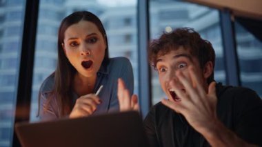 Heyecanlı yeni başlayanlar, akşam iş yerinde laptopta harika haberler okuyarak seviniyorlar. Duygusal iş arkadaşları 5 milyon veriyor. İki yönetici, karanlık ofiste başarılı oldukları için çok mutlular.