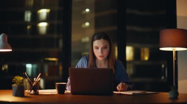 Çok mutlu bir bayan dizüstü bilgisayarda gece işyerinde harika haberler okuyor. Heyecanlı iş kadını, akşam ofisinde online galibiyeti kutluyor. Mutlu kadın serbest çalışan neşeli iş teklifi evet işareti gösteriyor.