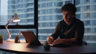 Geç çalışan, ofis masasında dizüstü bilgisayar projesini hazırlıyor. Genç girişimci iş planlama stratejisi sadece akşam işyerinde. Ciddi bir yönetici içeride fazla mesai yapıyor.