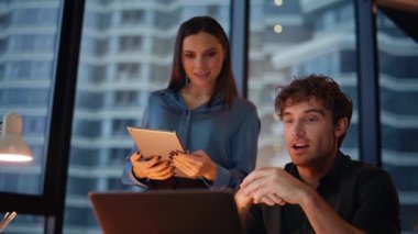 Ortaklar karanlık ofis kapanışında işbirliği yaparak projeyi videoya alarak tartışıyor. İnternetteki toplantıda konuşan iki meslektaşım tablet verilerini okuyorlar. Sanal konferansta müşterilere danışmanlık yapan işletmeciler.