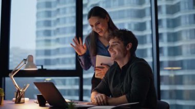 Meslektaşlar bilgisayarla video görüşmelerine akşam iş yerinde başlarlar. Çevrimiçi toplantıda projesini sunan kendine güvenen iş kadını işadamı. İki iş arkadaşı karanlık ofisteki sanal konferansta konuşuyor.