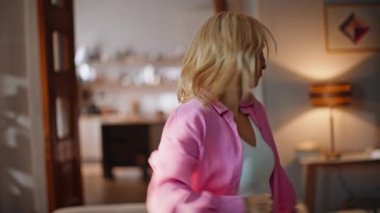 Evde dans eden kaygısız sarışın. Güneşli apartman dairesinde parti yapan güzel bir kadının portresi. Neşeli bayan hafta sonu el hareketleriyle eğleniyor. Yurtiçi parti kavramı 