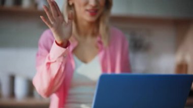 İnternetteki kadın, ev mutfağında bilgisayar görüntülerini selamlıyor. Mutfaktaki iş arkadaşlarına el sallayan bilgisayarlı internet sohbetinden mutlu bir serbest yazar. Olumlu bayan uzak konferansı