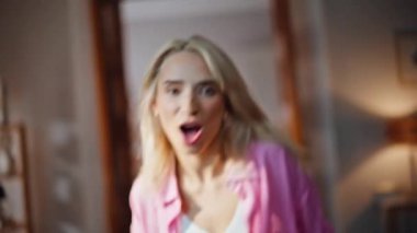 Güneşli bir dairede dans eden neşeli sarışın portresi. Mutlu, gülümseyen, el kol hareketi yapan, hafta sonundaki dairede kameraya bakan kız. Evde tek başına dans eden kaygısız kadın dansçı. 