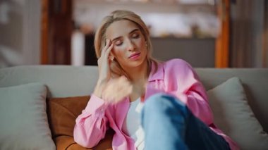 Baş ağrısı çeken kadın cep telefonuyla görüşmesini bitiriyor. Hasta kadın akıllı telefonu koltuğa oturtmaktan yoruldu. Hüsrana uğramış kız oturma odasında migren ağrısı çekiyor. 