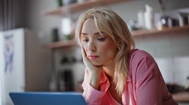 Evde ofis portresi yaparken baş ağrısı çeken yorgun bir serbest yazar. Stresli kadın hafta sonu yakın planda dizüstü bilgisayar kullanıyor. Oldukça hayal kırıklığına uğramış bir iş kadını. Gözlerini ovuşturuyor. Mutfakta kendini gergin hissediyor.