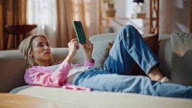 Yalancı kadın cep telefonu araklıyor, rahat bir ev kanepesi. Sosyal ağlardan keyif alan gülümseyen çekici kız dairede internet yayını yapıyor. Kaygısız neşeli bayan koltukta cep telefonuyla dinleniyor.