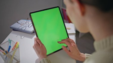 Öğrenci kız iş yerinde internet sörfü için kromakey tableti kullanıyor. Ofiste elinde yeşil ekran bilgisayar tutan kadın elleri dokunmatik ekrana dokunuyor. Bilinmeyen bayan tek başına çalışıyor.