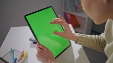 Öğretmen internet sörfü için krom anahtar tableti kullanıyor. Ofiste elinde yeşil ekran bilgisayar tutan kadın elleri dokunmatik ekrana dokunuyor. Okulda çalışan bilinmeyen öğretmen modelleme aygıtı 