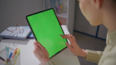 Öğretmenin elleri okulda yakın çekimde bilgisayar araklıyor. Tanımlanamayan eğitimci Chromakey tablet okuma sunumuna dokunuyor. Kadın parmakları yeşil ekran tarayıcı interneti uzaktan tarıyor