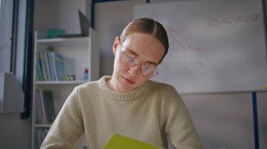 Sınıfta tek başına çalışan ciddi bir öğretmen. Genç, gözlüklü, profesyonel bir eğitimci ışık dolabında ev ödevlerini kontrol ediyor. Okuma sınavı okuyan bir kadın okula not bırakıyor. Meslek kavramı