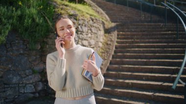 Mutlu bayan, güzel Spring City 'nin kapanış merdivenlerinde akıllı telefonları arıyor. Gülümseyen öğretmen merdivenlerden çıkıp cep telefonuyla konuşuyor. Sunny Park 'ta cep telefonu kullanan neşeli bir kadın.