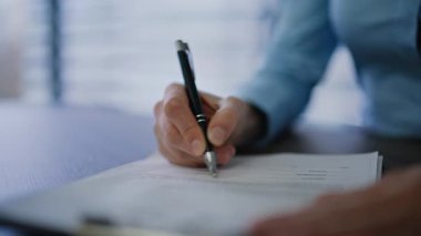 İş kadını elle imzalama sözleşmesi imzaladı. Kalemi ofis masasında tutuyor. Tanımlanamayan kadın yöneticinin işyerindeki yasal evraklara imza atması. Bayan Yönetici içeride finansal anlaşmayı yasallaştırdı.
