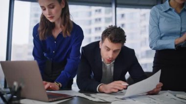 Profesyonel yöneticiler çalışma masasında veri işi projesini tartışıyorlar. Şirket ofisindeki belgeleri analiz eden odaklanmış liderler. Mali belgeleri inceleyen ekip toplantıda karar veriyor..