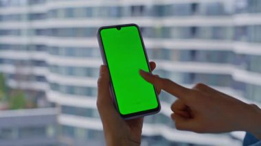 Serbest çalışan parmak krom tuşlu akıllı telefona dokunuyor. Pencereyi kapatarak online uygulamayı açıyor. Yeşil ekranlı cep telefonuyla internet alışverişi yapan tanınmayan bir kadın. Model cep telefonuyla mesaj gönderen bayan.