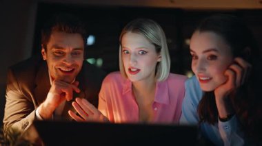 Rahat insanlar gece apartmanında toplanıyor. Yakın plan. Bilgisayarlı web kamerasıyla konuşan gülümseyen üç arkadaş Dark Home 'da haberleri paylaşıyorlar. Pozitif iş arkadaşları sanal konferansta sohbetin keyfini çıkarıyorlar.