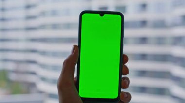 Parmaklar pencere kenarı görüntüsünden cep telefonuna dokunuyor. Tanımlanamayan iş adamı ofisteki yeşil ekranlı akıllı telefondan mesaj okuyor. Yönetici Chroma Key telefonundaki video çağrısını açıyor.