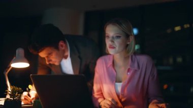 Çok çalışan iş arkadaşları, gece vardiyasında fazla mesai yapmakla meşguller. Ciddi bir işadamı, iş kadını dizüstü bilgisayarını kontrol ediyor. İki iş arkadaşı gece yarısı proje üzerinde çalışıyor..