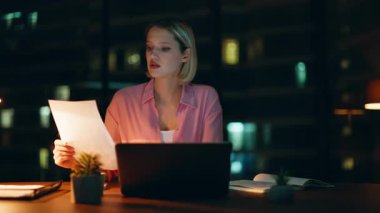 Profesyonel muhasebeci gece geç saatlerde lamba ışığında evrak işlerini hallediyor. Ciddi bir iş kadını, gece ofisinde strateji üzerine finansal istatistiksel düşünce içeren belgeler okuyor. Sarışın fazla mesai yapıyor..