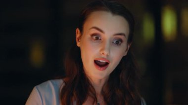 Şaşırtıcı serbest çalışanın sevindirici haberleri var. Gece işyerinde yakın çekim. Evet hareketi gösteren finansal gelir elde eden şaşkın kadın girişimci. Heyecanlı iş kadını iş başarısının tadını çıkarıyor..