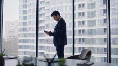 Başarılı bir iş adamı cep telefonunda duygusal evet hareketi gösteren neşeli bir mesaj veriyor. Çok mutlu bir yönetici akıllı telefon okuyor. Harika bir haber. Şaşırtıcı yönetici telefon aramasından zevk alıyor..