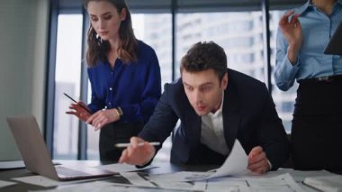 Yatırım şirketinin iş yerinde birlikte çalışarak mali istatistikleri inceleyen ofis çalışanları. Ciddi iş arkadaşları proje üzerinde çalışıyor. Üç yönetici iş planı üzerinde kafa yoruyor.