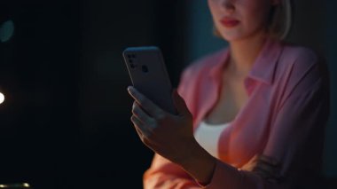 Karanlık odada el ele tutuşan bir bayan cep telefonu. Güzel bir iş kadını cep telefonuyla mesajını okuyor. Rahat kadın, akıllı telefondan internette sörf yapıyor..
