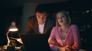 Endişeli çalışanlar, gece işyerinde yazılım hatalarını tartışıyorlar. Endişeli iş kadını dizüstü bilgisayar arıyor. Mesai saatlerinde iş meselelerini çözmekte zorlanan iki işçi