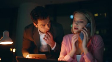 İşbirlikçi yöneticiler gece ofisindeki akıllı telefonlardan bahsediyorlar. Başarılı pazarlıkların tadını çıkarın. Gülümseyen meslektaşlar telefon ederek başarıyı kutluyorlar. Mutlu takım mobil konuşmada harika haberler duyuyor.