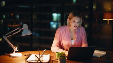 Çevrimiçi öğrenci, dizüstü bilgisayarından gelen bilgileri not ediyor. Gece apartmanındaki iş yerini kapatıyorlar. Ciddi kadın serbest çalışan, e-ticaret projesi uzatması yapıyor. Profesyonel yönetici geç saatlere kadar bilgisayar başında çalışıyor..