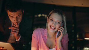 Geç saatlerde ofis işleri ile meşgul olan birden fazla iş arkadaşı. Gülümseyen iş kadını, akıllı telefon işadamını arıyor ve akşam tableti dinliyor. Müşteri telefon danışmanlığında işbirliği yapan iki çalışan.