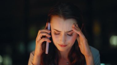Stresli bir kadın, akıllı telefonları dinliyor ve karanlık odada kötü haberler veriyor. Sorunlu iş kadını gece ofisinde cep telefonunu arıyor. Endişeli kadın patron iş hatasından şikayetçi..