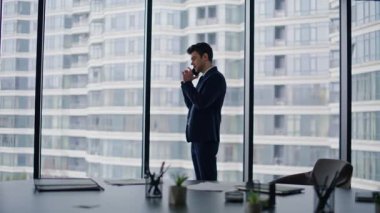 Akıllı telefondan konuşan bir şirket çalışanı. Lüks ofis kapanışı. Kendine güvenen işadamı iş stratejisini cep telefonuyla açıklıyor. Zengin lider cep telefonu konuşmasında işi tartışıyor.