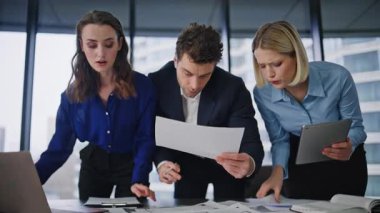 Ekip üyeleri iş belgelerini incelemek için ofis kapanışında işbirliği yapıyor. Profesyonel yöneticiler evrak işleriyle meşgul. Şirket geliştirme stratejisi üzerinde çalışan üç meslektaşım.
