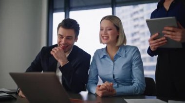 Modern kurumsal iş yerinde ofis personeli dizüstü bilgisayarla çevrimiçi konferans veriyor. Grup iş adamları video görüşmesinde pazarlama stratejisini tartışıyor. Gülümseyen iş arkadaşları birlikte bilgisayar kameralarıyla konuşuyorlar.