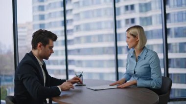 Yatırım danışmanı, finans şirketinin kapanış ofisindeki iş adamına sözleşme öneriyor. Kendine güvenen yatırımcı anlaşmaya imza atıyor. Gülümseyen iki ortak el sıkışıyor ve işbirliğinin tadını çıkarıyor.