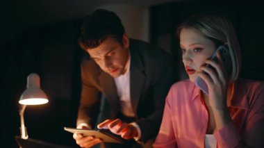 Gece şirketinin iş yerinde çalışan meşgul yöneticiler. İş kadını konuşuyor, cep telefonu işadamı tablet verilerini kontrol ediyor. İki çoklu görev arkadaşı aşırı yüklü iş görevleri.