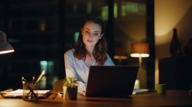 Fazla mesai çalışanı, bilgisayar ekranını lamba ışığında kapatma hatasını hayal kırıklığına uğrattı. Stresli iş kadını geceleri laptopta kötü haberler okuyor. Endişeli kadın çalışan bilgisayar kapanırken hayal kırıklığı yaşıyor..