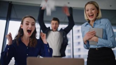 Grubun galipleri laptopta sevinçle kahkahalar atıp zaferi kutluyor. Coşkulu iş adamları sevinçli takım çalışması başarısını kucaklıyor. Mutlu meslektaşlar beş kişiye finansal başarı sunuyor.