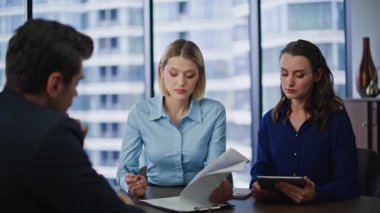 İş anlaşmasını imzalayan kadın yönetici, ofis konferans odasında iş arkadaşlarıyla yakın çekim yapıyor. Gülümseyen iş kadını iş adamı elini sıkıyor. İşadamları şirket sözleşmesi imzalıyor