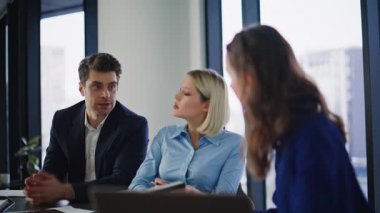 İş kadını şirket brifinginde konuşuyor. Laptop 'ta pazarlama stratejisini sunuyor. Gülümseyen meslektaşlar el çırparak konuşmalarını tamamlıyorlar. Ofis arkadaşları iş projesini tartışıyorlar..