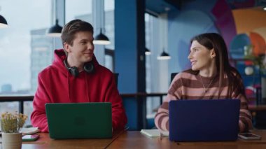 İş adamları ofisteki açık alanda başarılı takım çalışması görünümlü dizüstü bilgisayarların keyfini çıkarıyorlar. İki meslektaş, e-ticaret projesinde beş tatmin edici işbirliği yapıyor. Çalışan bilgisayarlarda gülümseyen iş arkadaşları.