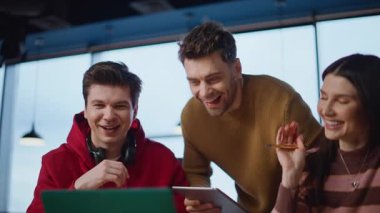 Mutlu iş arkadaşları yaratıcı fikirleri tartışmak için video aramasından hoşlanırlar. Gülümseyen ofis yöneticileri birlikte dizüstü bilgisayarla konuşurken gülüyorlar. Neşeli çalışanlar iş yerinde arkadaşça video toplantısı.