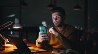 Karanlık İş Yeri 'nde cep telefonuna internetten arama yapan serbest çalışan biri. Ciddi bir yönetici akıllı telefondan internet alımı yapıyor. Düşünceli iş adamı, gece geç saatlerde telefon mesajı okuyor..