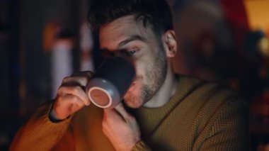 Neşeli bir adam koyu renkli daireden arıyor ve yakın plan kahve içiyor. Oturma odasında cep telefonundan konuşan serbest çalışan biri içkinin tadını çıkarsın. Arkadaş canlısı adam akıllı telefondan konuşuyor sıcak çay yudumluyor evde.