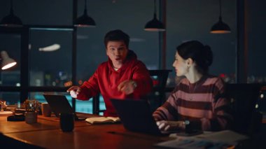 Heyecanlı iş arkadaşları, gece iş yerinde başarılı bir projenin tadını çıkarırken el çırpıyor. Coşkulu iş arkadaşları beş sevinçli iş başarısı sunuyor. Gülümseyen yöneticiler anlaşma kazanırken dizüstü bilgisayar görüyorlar