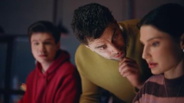 Dizüstü bilgisayarlarda yardımcı teknik direktörler gece geç saatlere kadar çalışırlar. Deneyimli bir yönetici karanlık ofisteki online projede iki stajyere yardım ediyor. Takım arkadaşları mesai saatlerinde beyin fırtınası yapıyor.