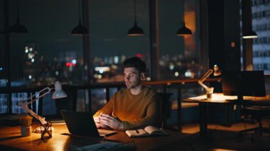 Elinde kahve fincanı tutmaktan yorgun düşmüş bir programcı. Gece vardiyasında sıcak içecek içen, dizüstü bilgisayarı olan bir gece çalışanı. Ciddi bir profesyonel, fazla mesaiye ara veriyor..