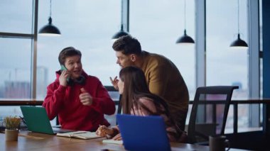 Mutlu çalışanlar, modern çalışma alanındaki cep telefonlarında duydukları haberlere çok sevindiler. Heyecanlı ekip üyeleri iş başarısı telefon aramasına seviniyor. Gülümseyen meslektaşlar birlikte başarıyı kutluyor..